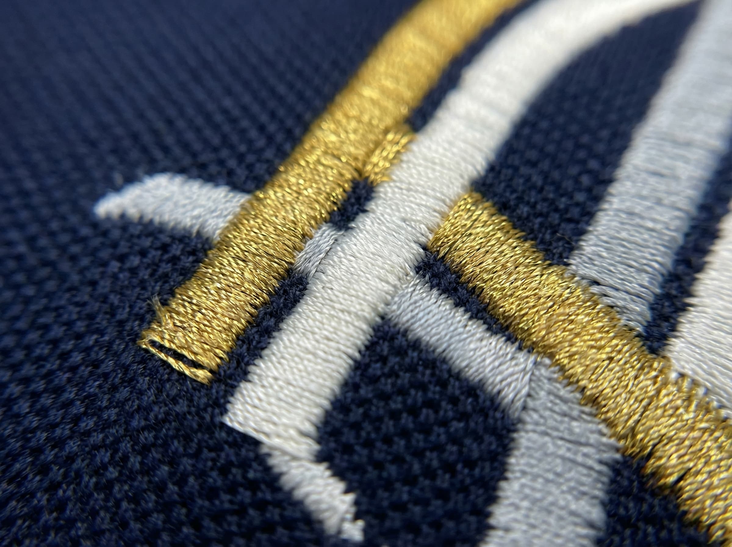 Close-up of Night Owls embroidered crest on navy polo